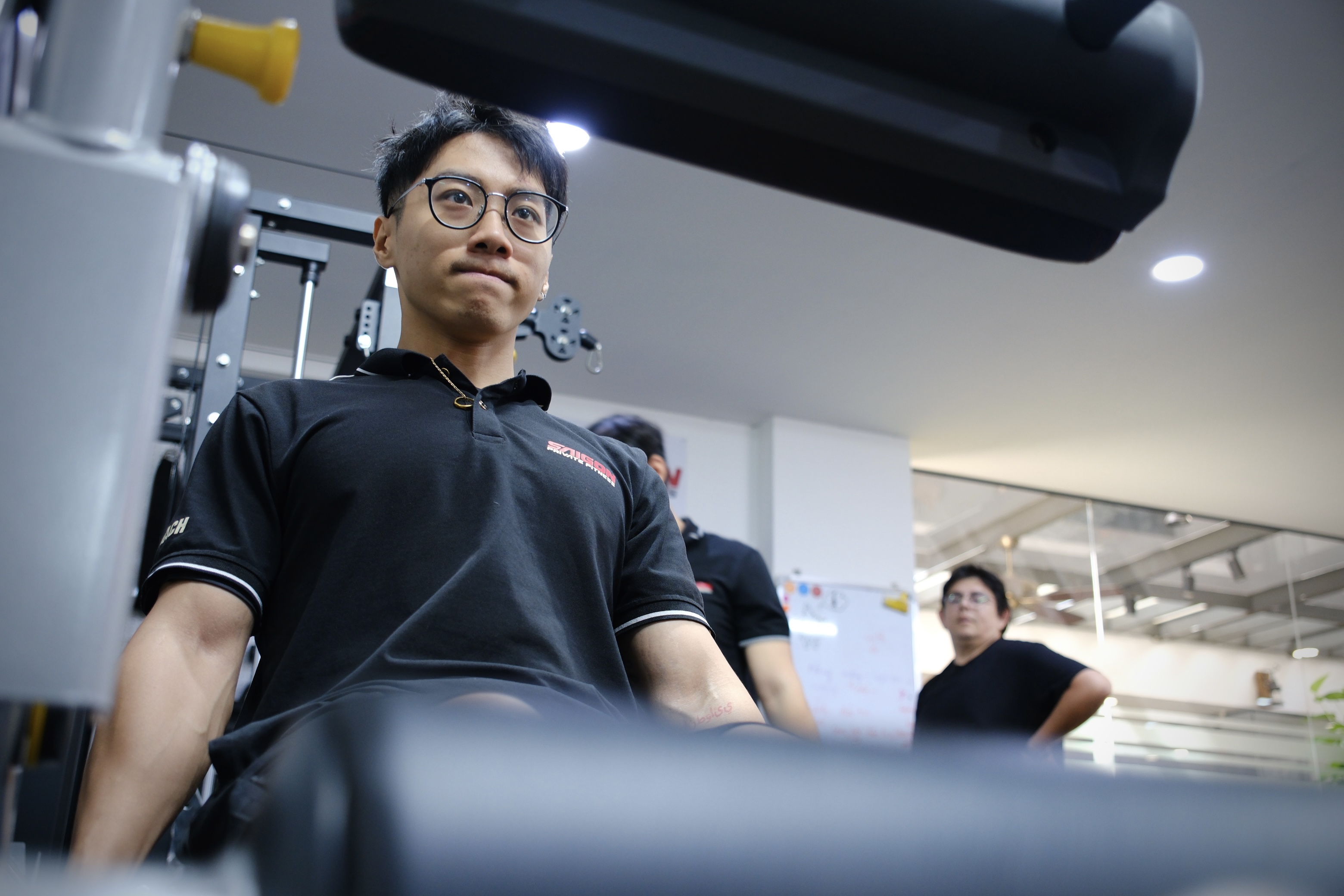 Trainer assisting with form on a deadlift